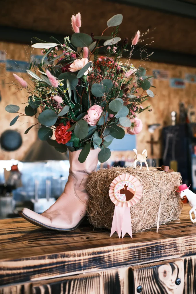 Détail de décoration florale dans une santiag rose sur botte de foin au CD Little Ranch à Maillane – Studio Argo